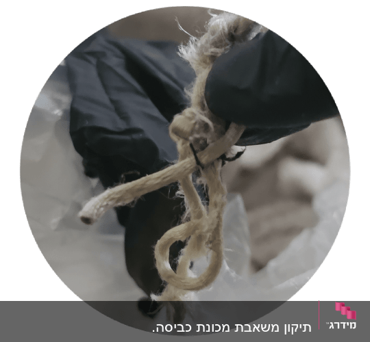 יד בכפפה מחזיקה סיבים שהוצאו במהלך תיקון מכשיר חשמלי